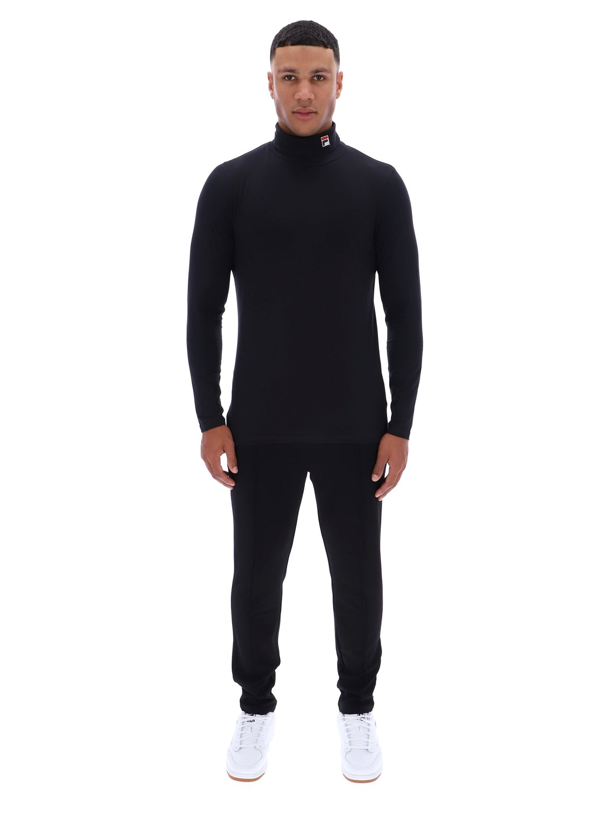 Man wearing a black turtleneck and pants on a white background