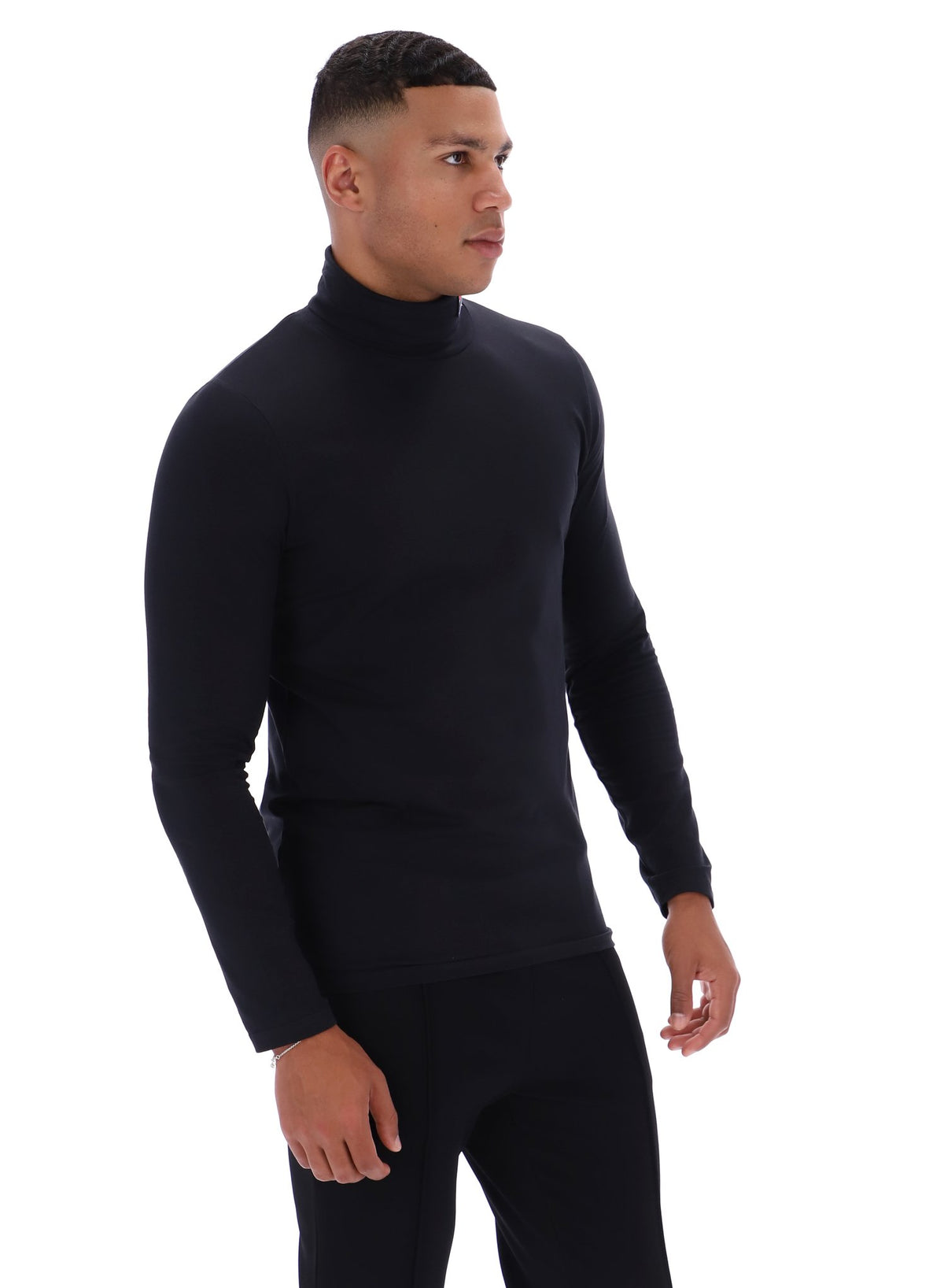 Man wearing a black turtleneck and pants on a white background