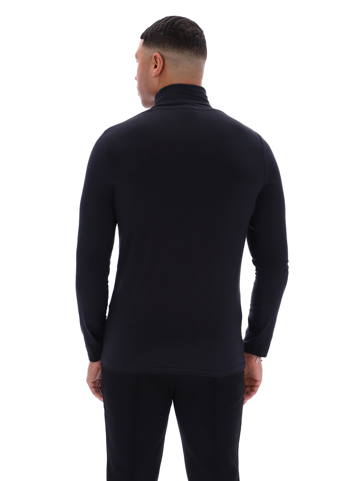 Man wearing a black long-sleeve shirt and pants on a white background