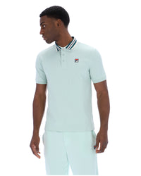 Man wearing a light green polo shirt with a small FILA logo on the chest, paired with matching joggers, against a white background
