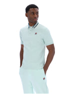 Man wearing a light green polo shirt with a small FILA logo on the chest, paired with matching joggers, against a white background