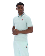 Man wearing a light green polo shirt with a small FILA logo on the chest, paired with matching joggers, against a white background