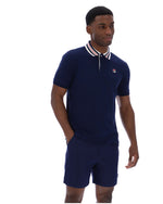 Man wearing a navy blue polo shirt and shorts set with a visible brand logo on a white background