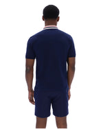 Man wearing a navy blue polo shirt and shorts set on a white background