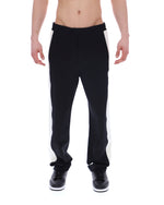 Person wearing black pants on a white background