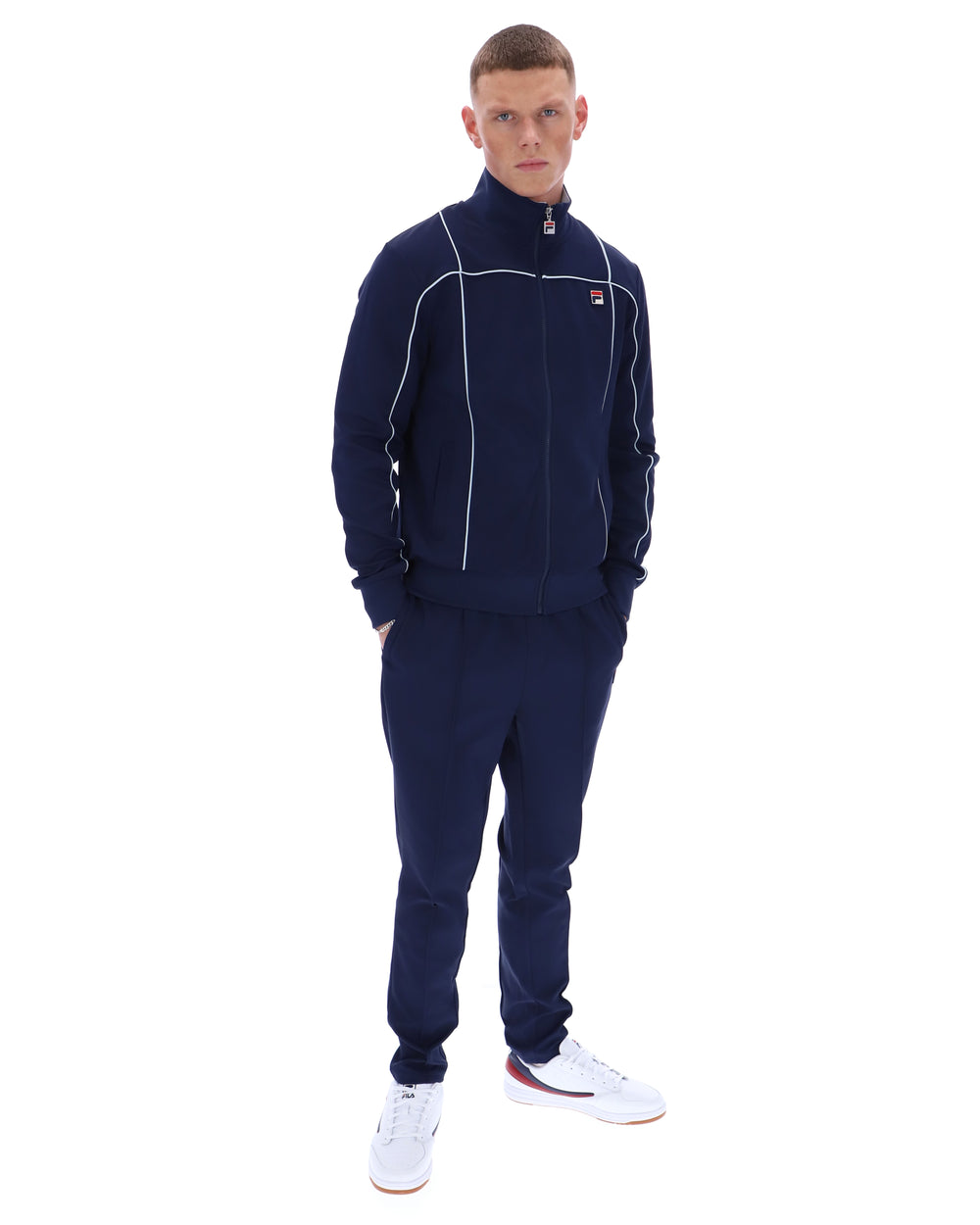 Man wearing a navy tracksuit with a brand logo on a white background