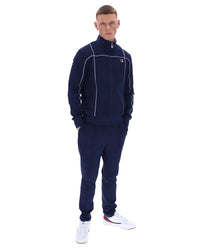 Man wearing a navy tracksuit with a brand logo on a white background