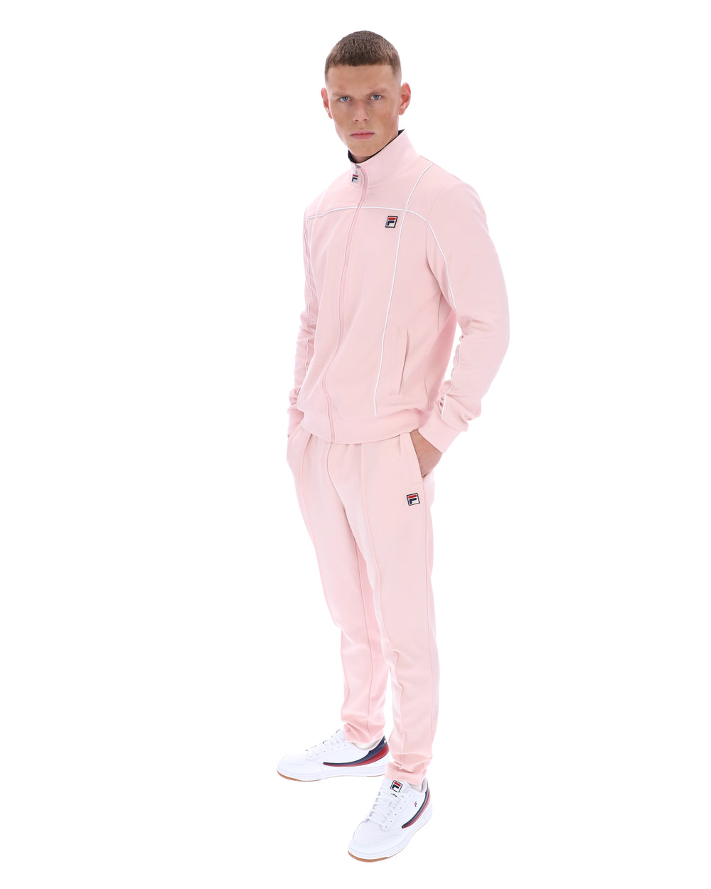 Person wearing a pink tracksuit with a brand logo on a white background