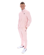 Person wearing a pink tracksuit with a brand logo on a white background