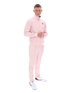 Man wearing a pink tracksuit with a brand logo on a white background