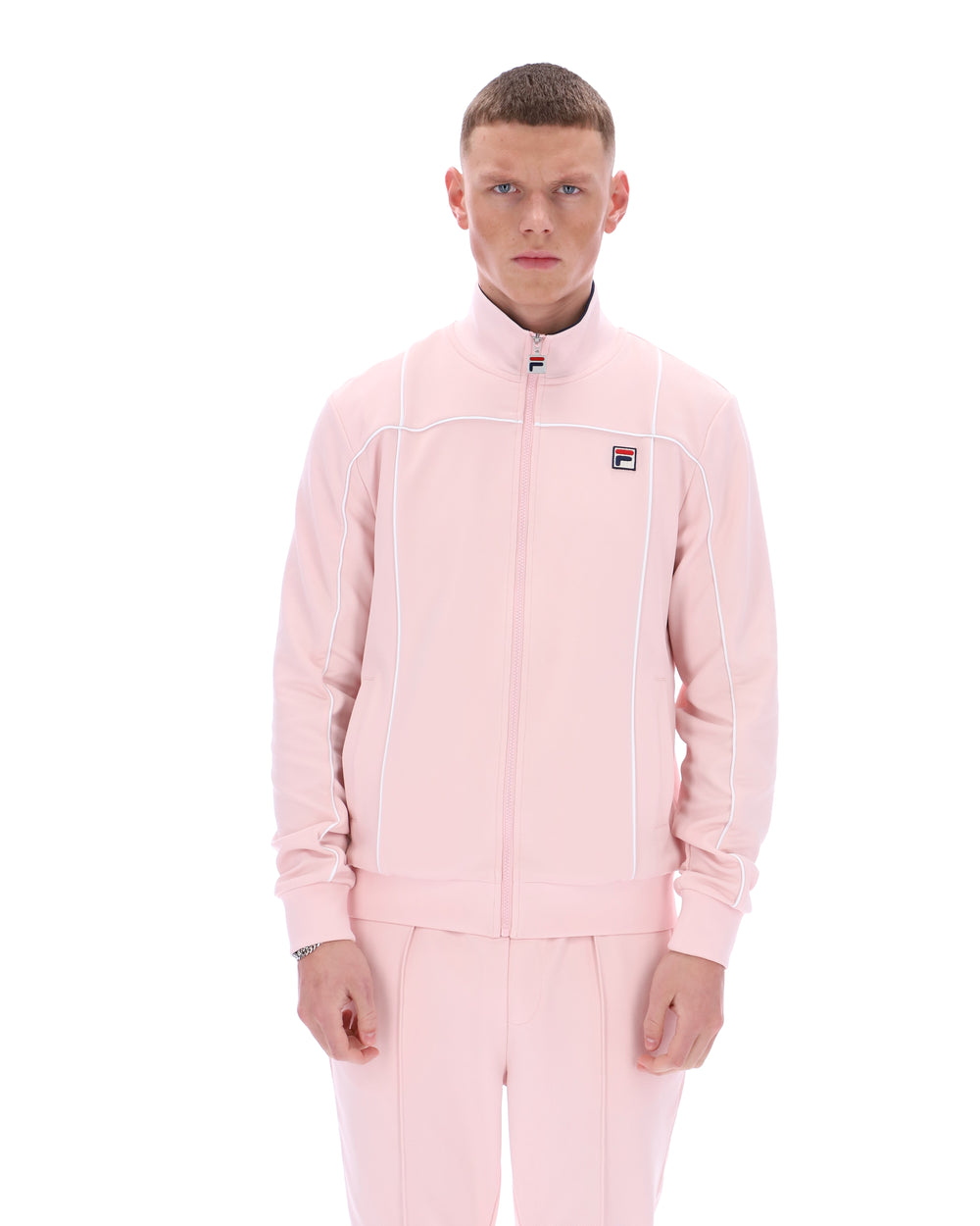 Person wearing a pink tracksuit with a visible brand logo on a white background