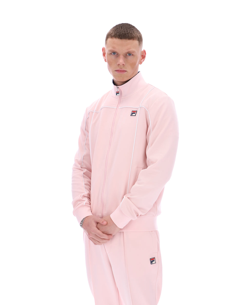 Person wearing a pink tracksuit with a brand logo on a white background
