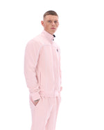Man wearing a pink tracksuit on a white background