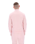 Person wearing a pink tracksuit on a white background