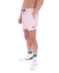 Person wearing pink shorts with a visible brand logo on a white background
