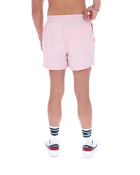 Person wearing light pink shorts on a white background