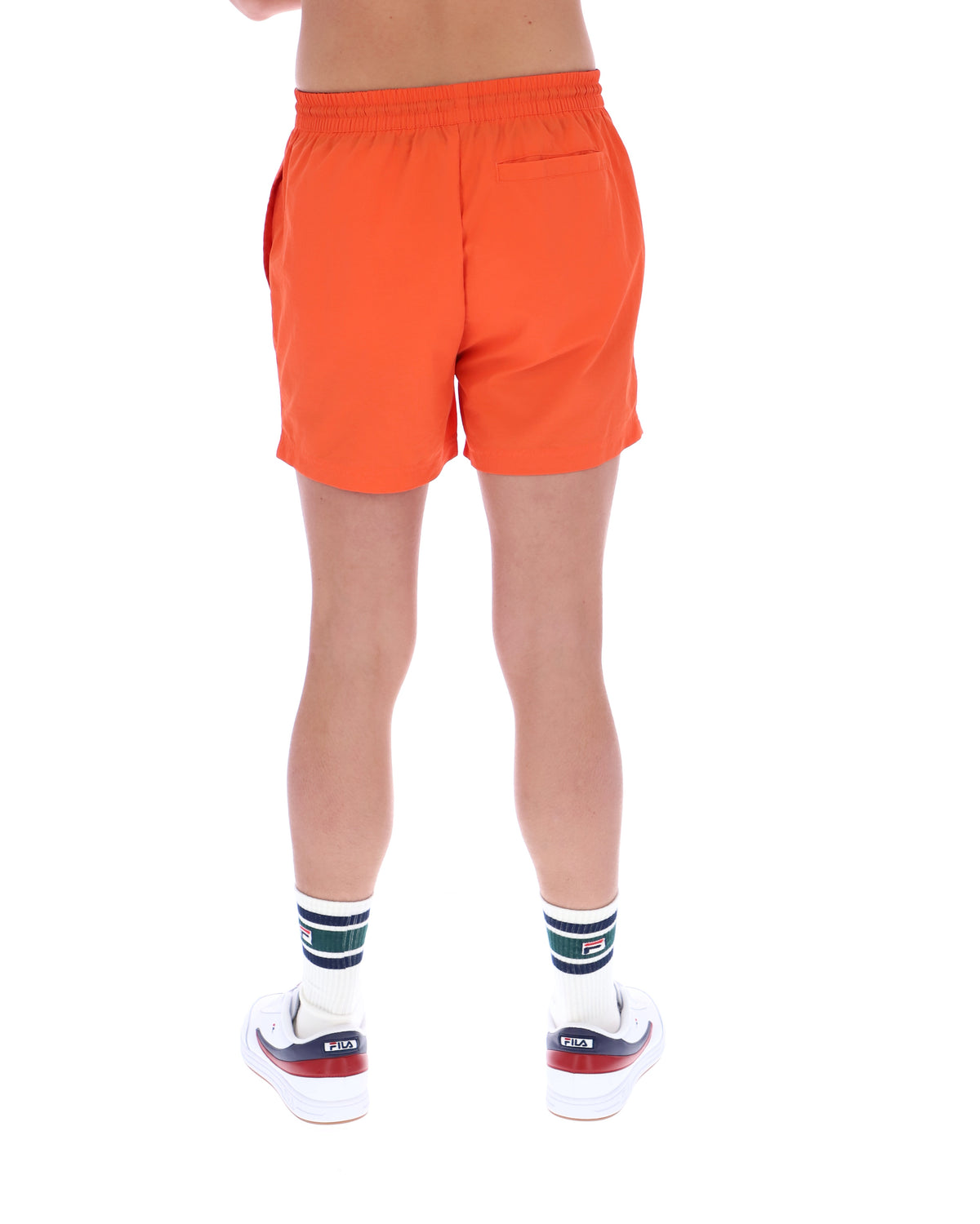 Orange shorts worn by a person on a white background
