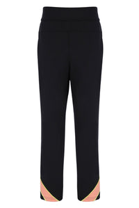 A pair of women's tennis track pants with colour blocks in peach pink and yellow on the sides, featuring an elastic waistband and branded with the FILA logo.
