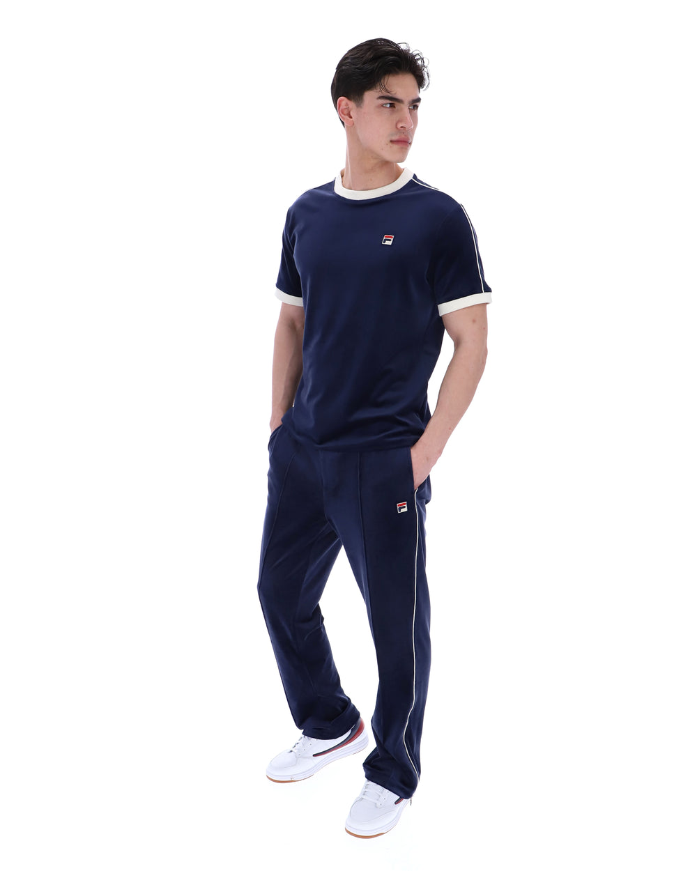 Person wearing a navy tracksuit with a brand logo on a white background