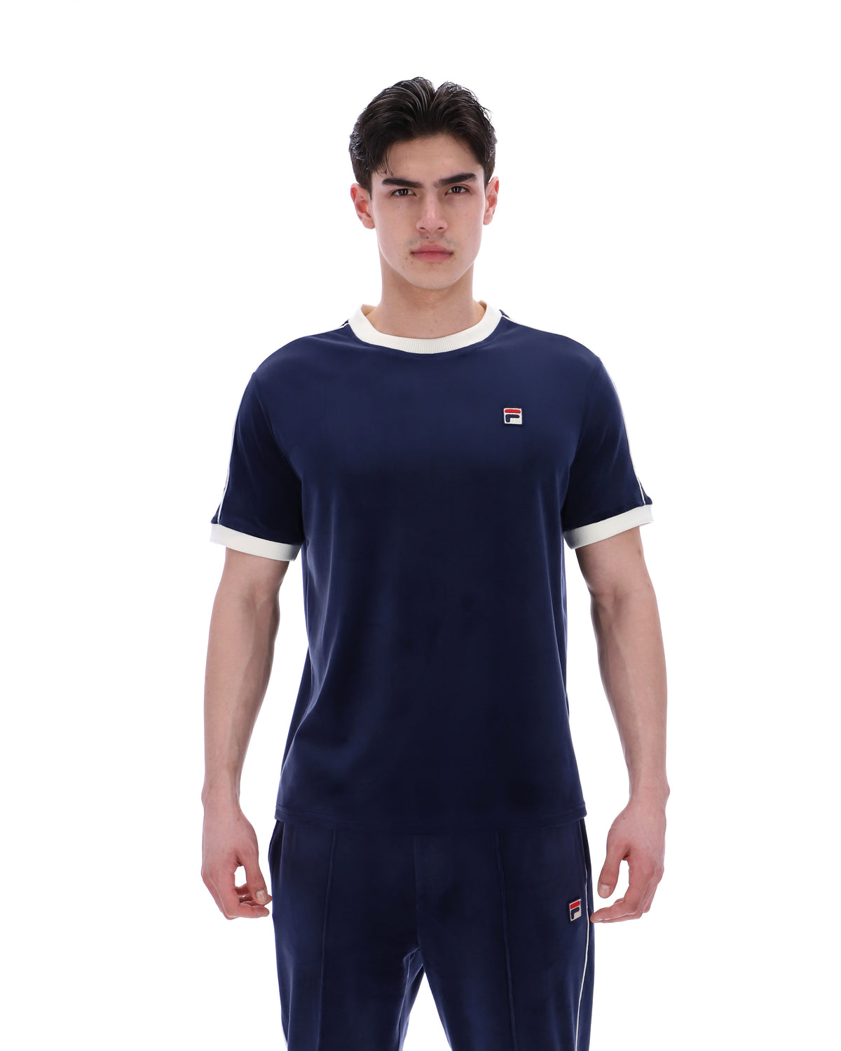 Man wearing a navy blue t-shirt with white trim and logo on a white background