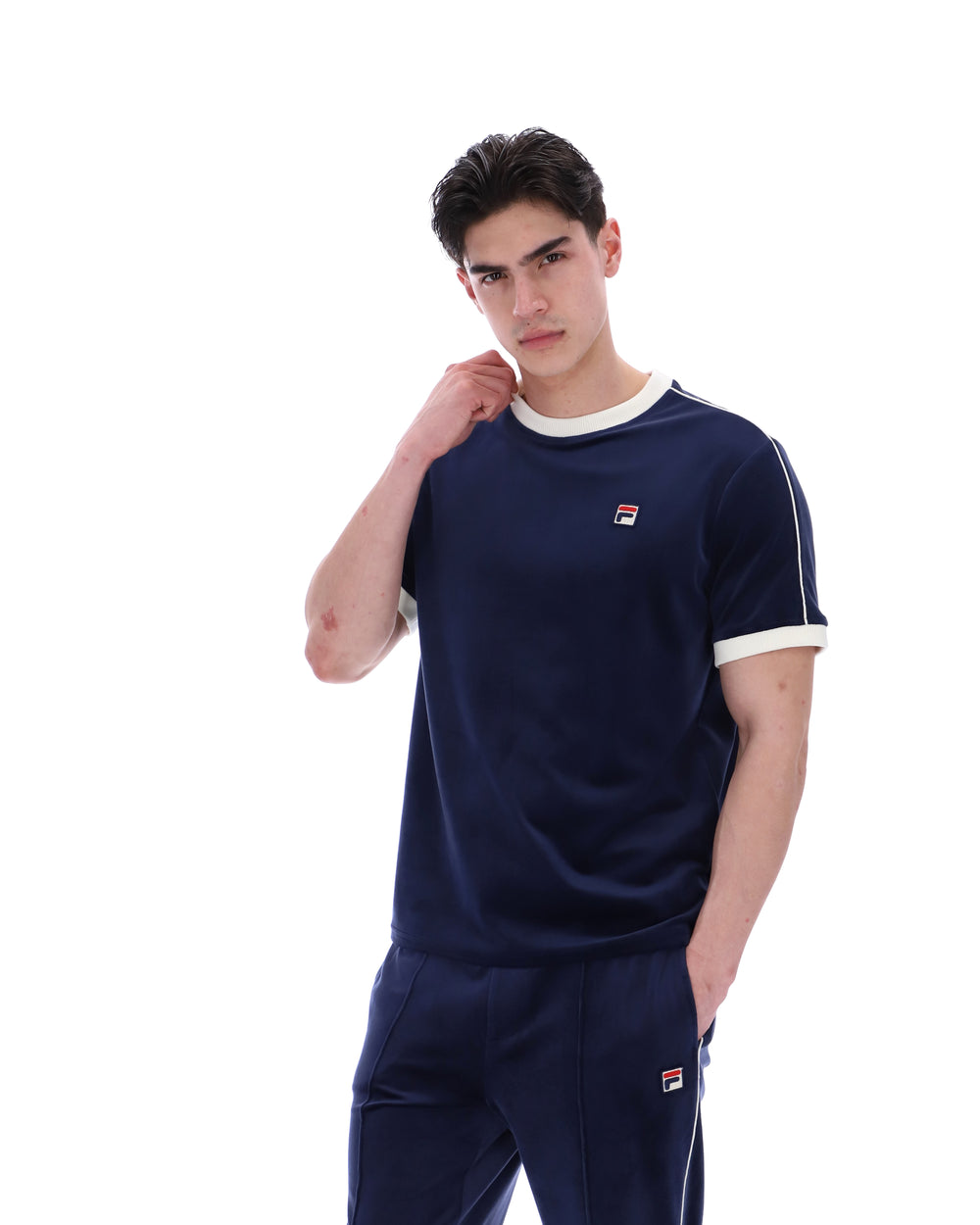 Man wearing a navy tracksuit with a brand logo on a white background