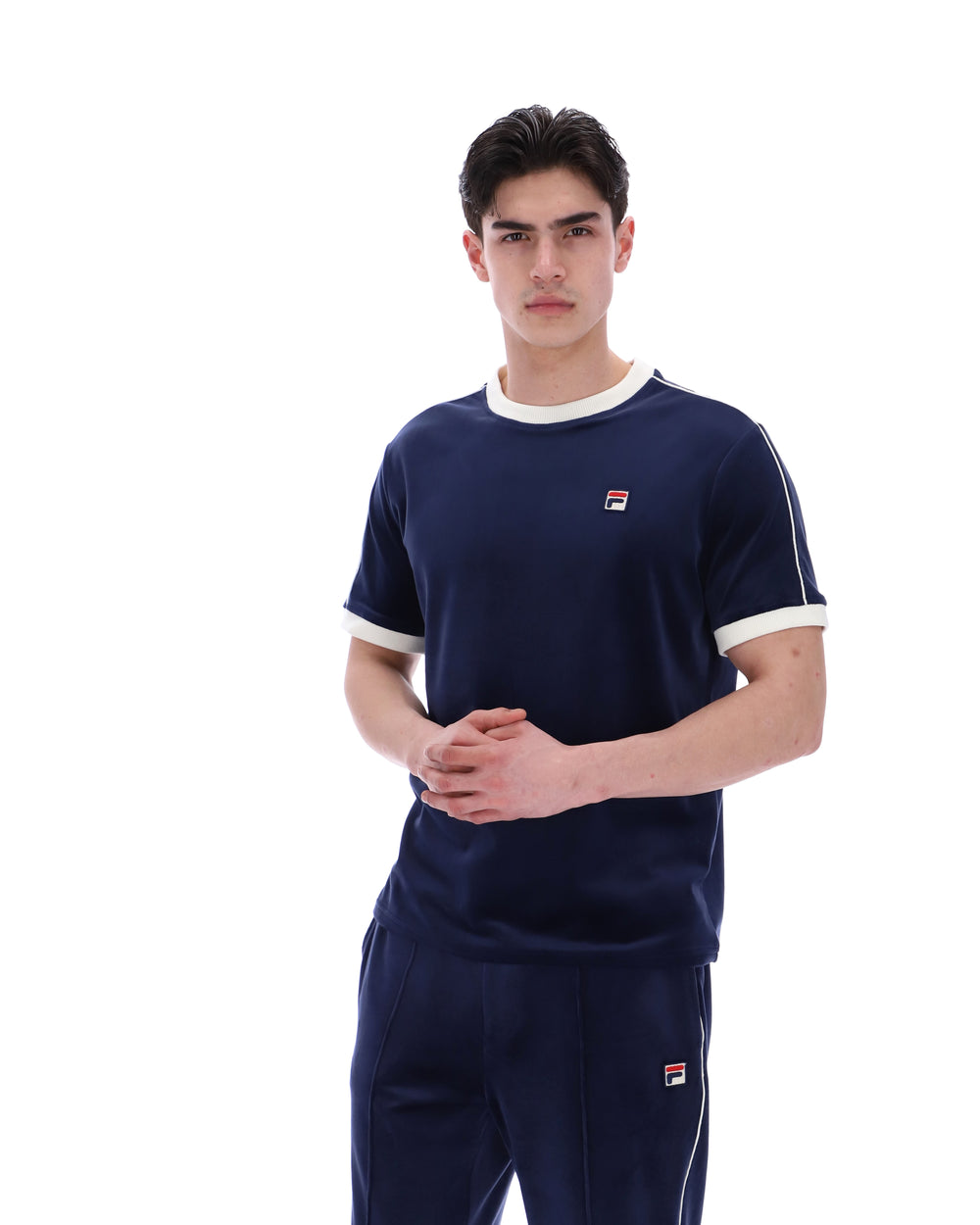 Man wearing a navy tracksuit with a logo on a white background
