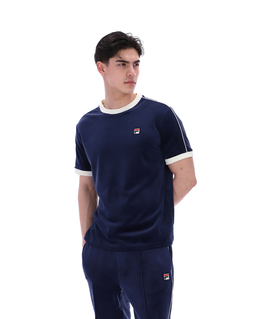 Man wearing a navy blue sports outfit with white accents on a white background