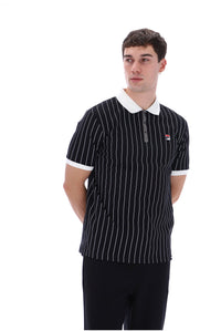 A man wearing a black short-sleeve polo shirt with thin white vertical pinstripes, a white collar, and a small red, white, and blue Fila logo on the left chest, photographed against a plain white background.