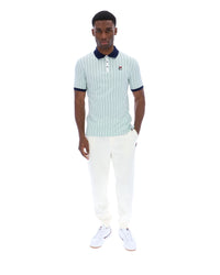 Man wearing a striped polo shirt and white pants on a white background