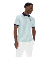 Man wearing a light blue striped polo shirt with a dark collar on a white background
