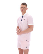 Man wearing a pink striped polo shirt and shorts with a visible brand logo on a white background