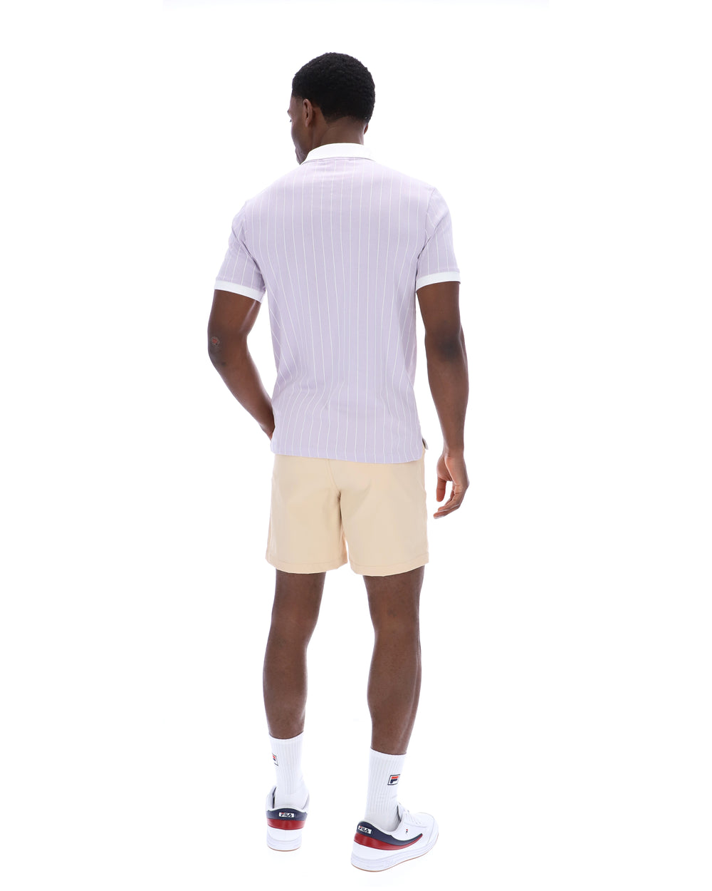 Man wearing a white polo shirt and beige shorts on a white background