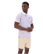 Man wearing a lilac striped polo shirt with a FILA logo on the chest, paired with beige shorts on a white background