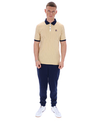 Man wearing a striped polo shirt and navy pants on a white background