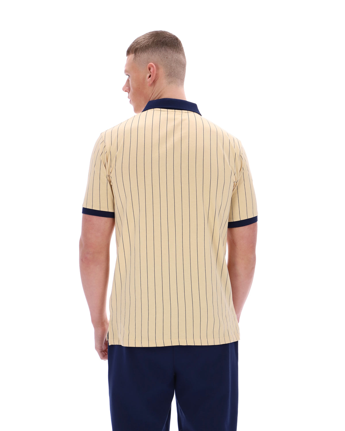 Man wearing a beige polo shirt with navy accents on a white background