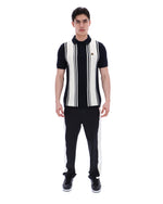 Person wearing a black and white striped shirt with a FILA logo on the chest and black pants on a white background