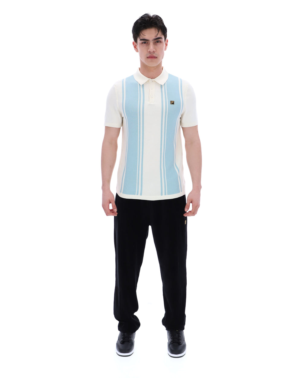 Man wearing a white polo shirt with blue stripes and black pants on a white background