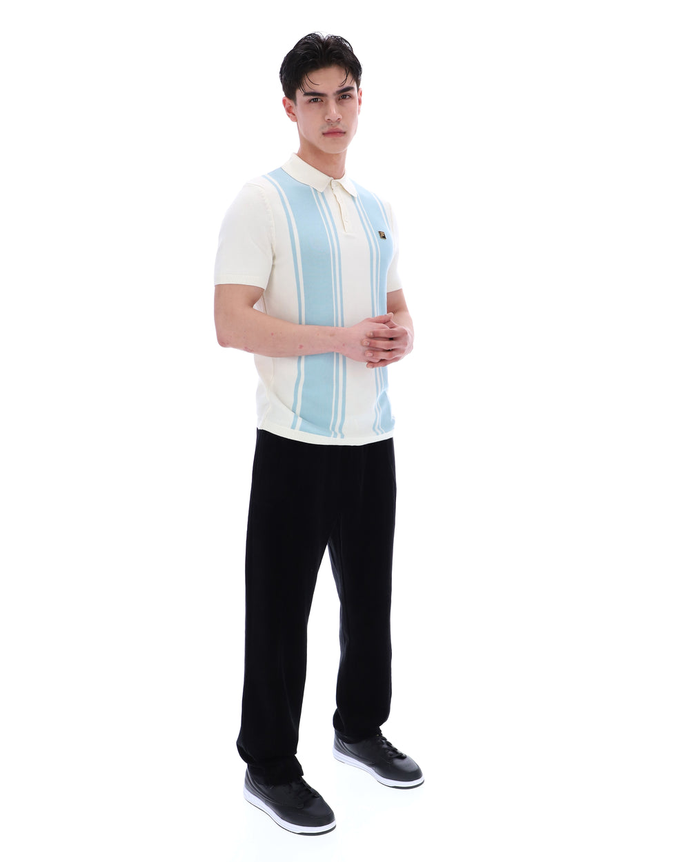 Man wearing a white polo shirt with blue stripes and black pants on a white background