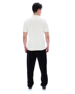 Man wearing a white polo shirt and black pants on a white background