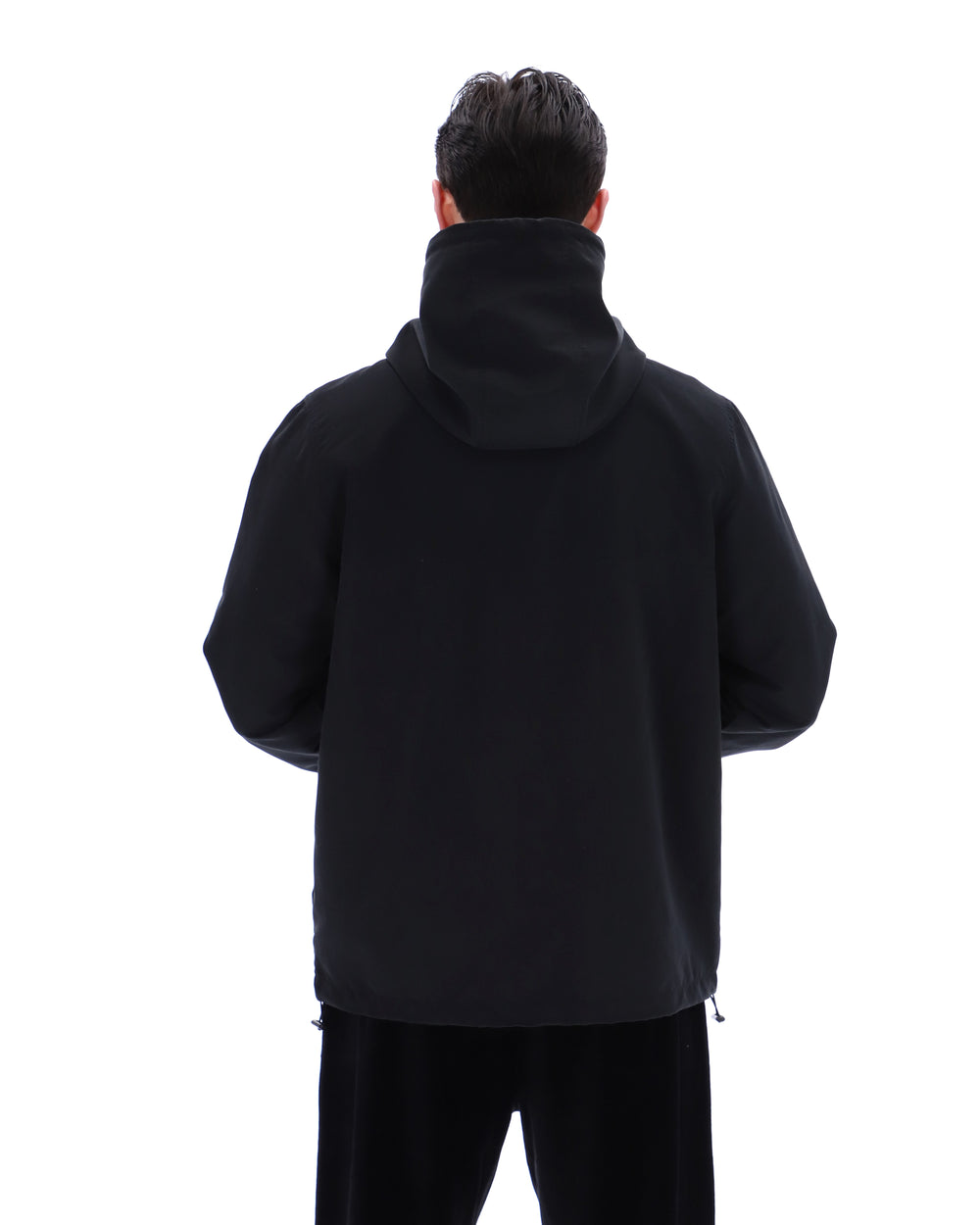 Person wearing a black hoodie from behind on a white background