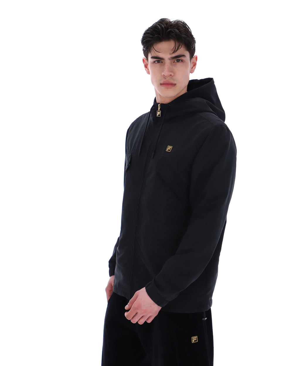 Man wearing a black hoodie with a small logo on a white background