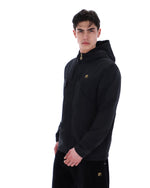 Man wearing a black hoodie with a small logo on a white background