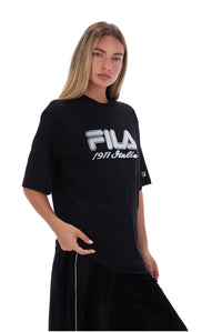 A woman modeling a black FILA t-shirt with a white graphic print on the front, paired with black pants, against a solid white background.