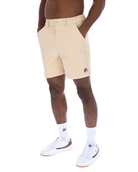 Displays a model wearing the Classic Beige 'FILA' branded Caruso Chino Shorts