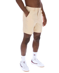 Displays a model wearing the Classic Beige 'FILA' branded Caruso Chino Shorts
