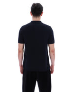 Person wearing a black polo shirt and pants on a white background