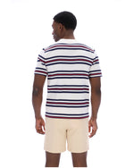 Man wearing a striped polo shirt and beige shorts on a white background