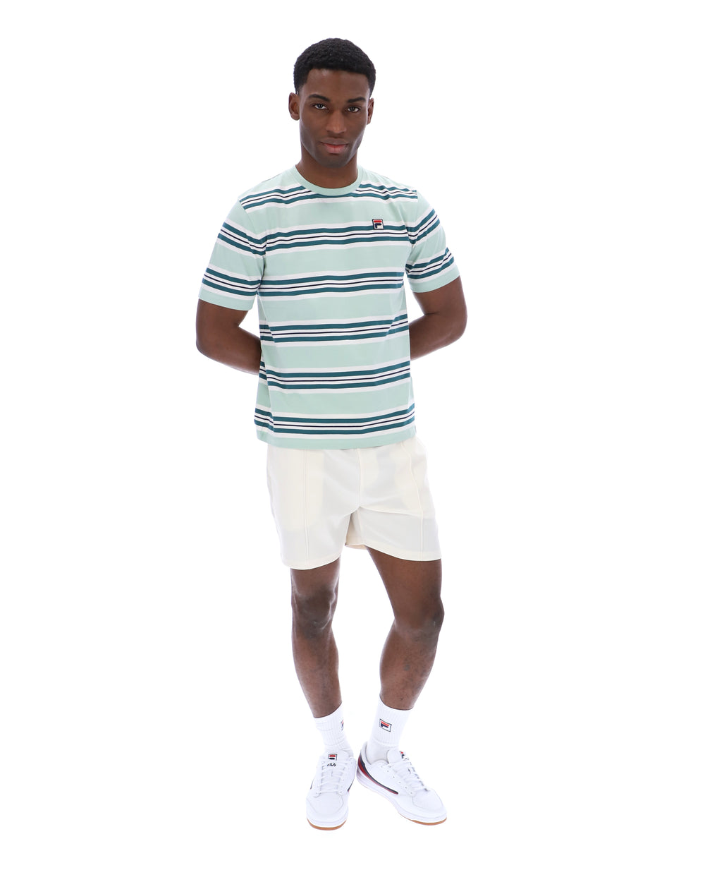 Man wearing a striped shirt and white shorts on a white background