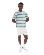 Man wearing a striped shirt and white shorts on a white background