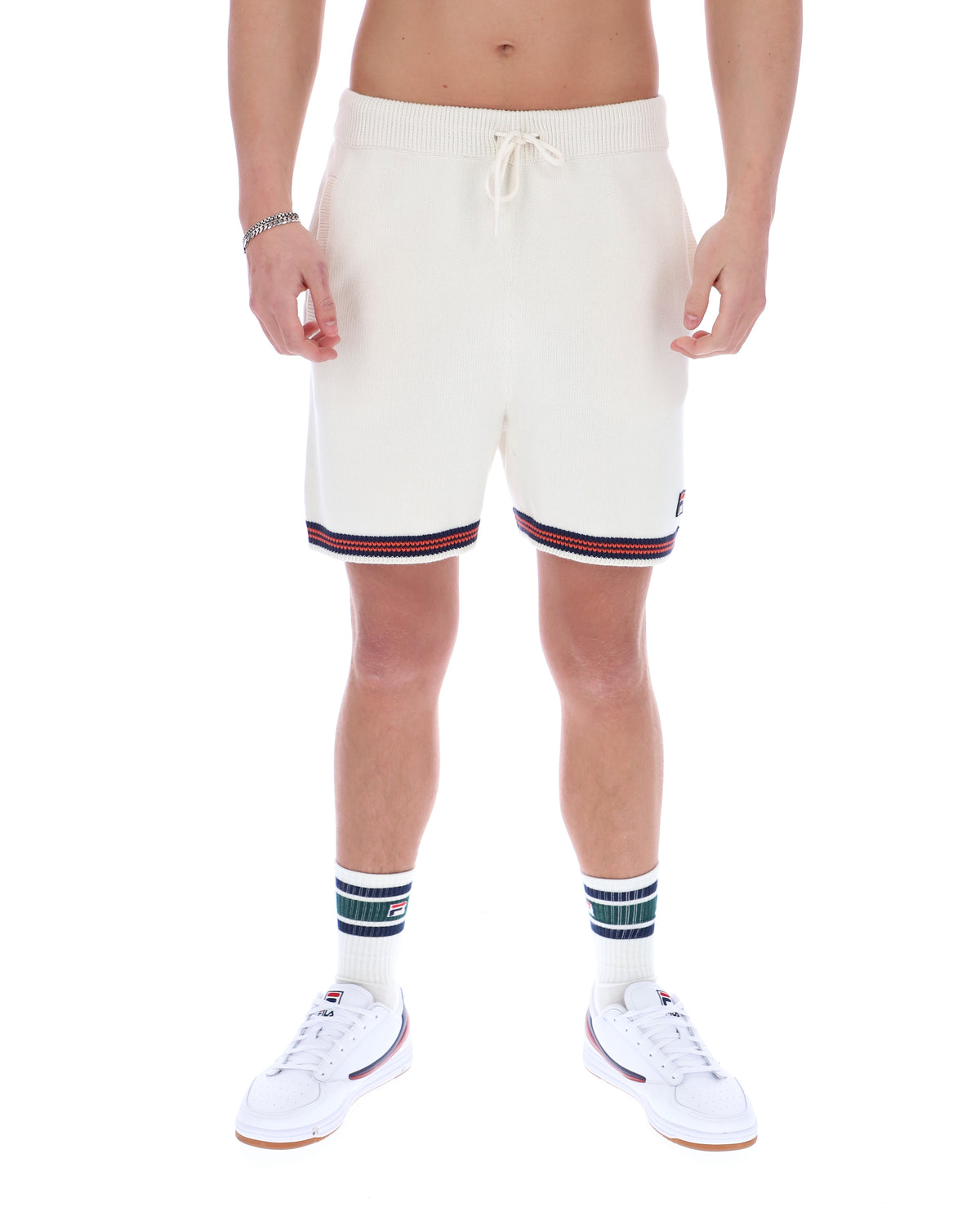 Person wearing white shorts with striped cuffs on a white background
